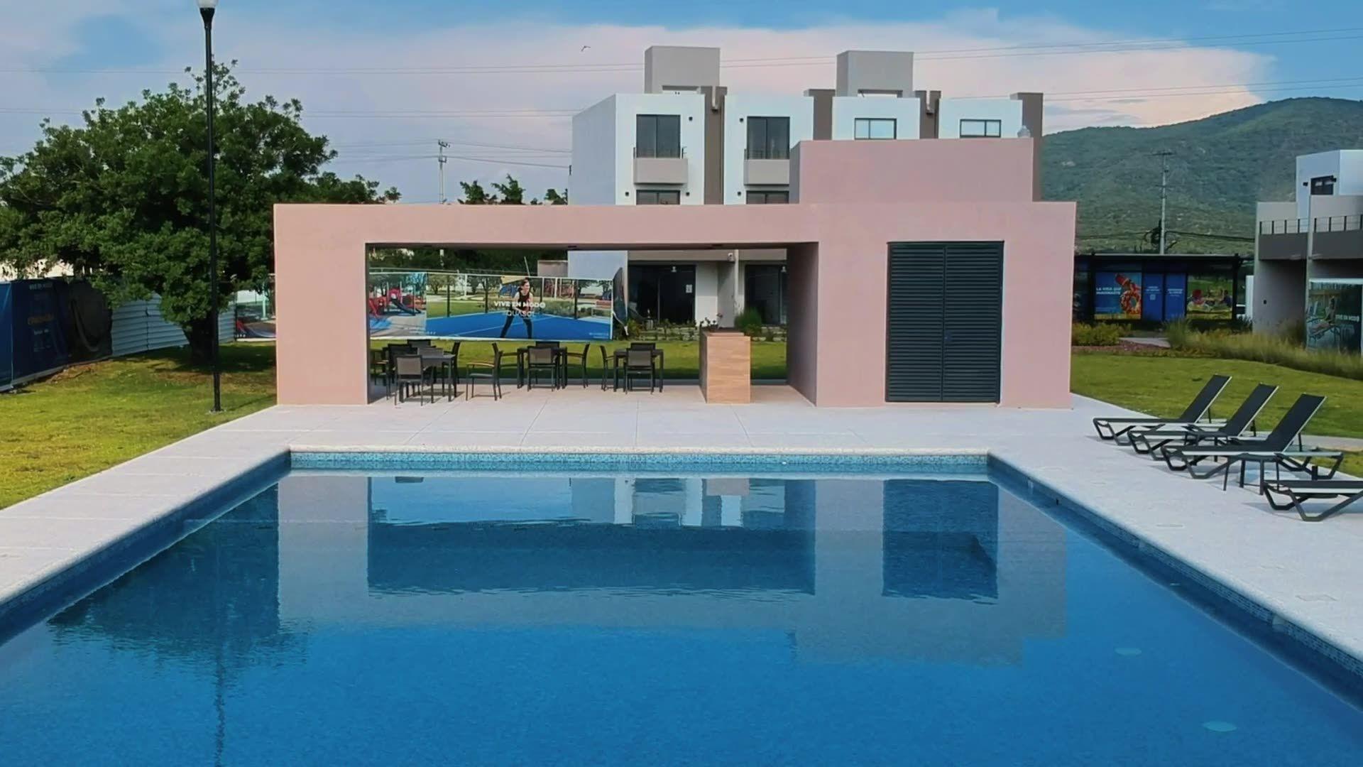 Alberca, palapa y áreas comunes de Aquasol Lifestyle con las casas al fondo